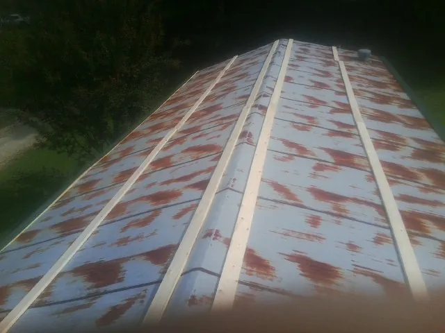 Rusted metal roof panels with new wood purlins before replacement — Storm Damage Roof Repair in Glenshaw by Roofing Brothers