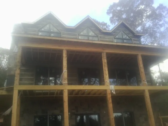 Dormers and porch framing on a large log home under construction — Roof Coating work by our crew in Glenshaw