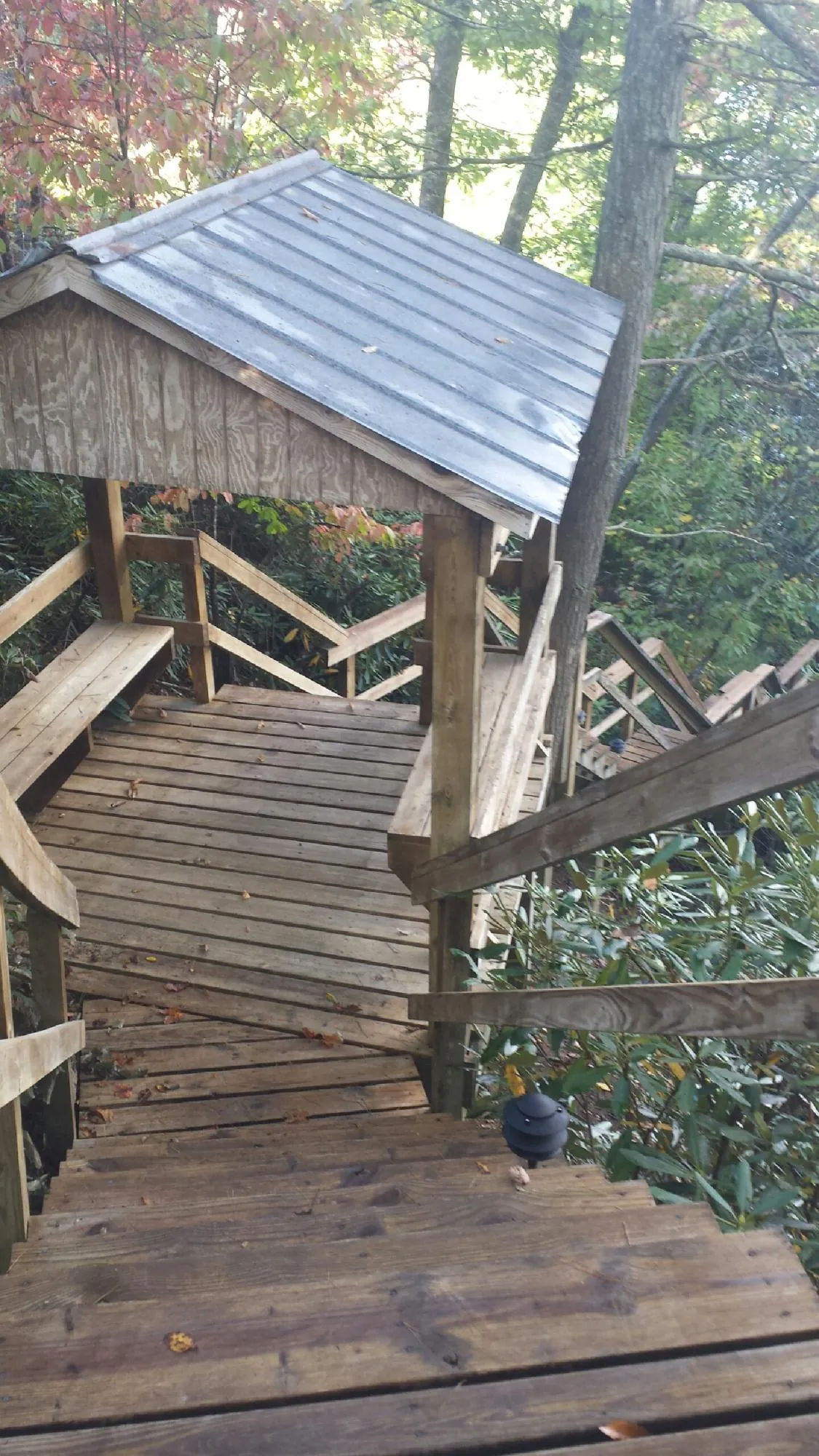 Metal roofed shelter over wooden steps on a wooded walkway — Skylight Repair & Installation work by our crew in Glenshaw